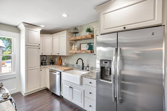 kitchen featuring sink, stainless steel appliances, light stone countertops, white cabinets, and dark hardwood / wood-style flooring