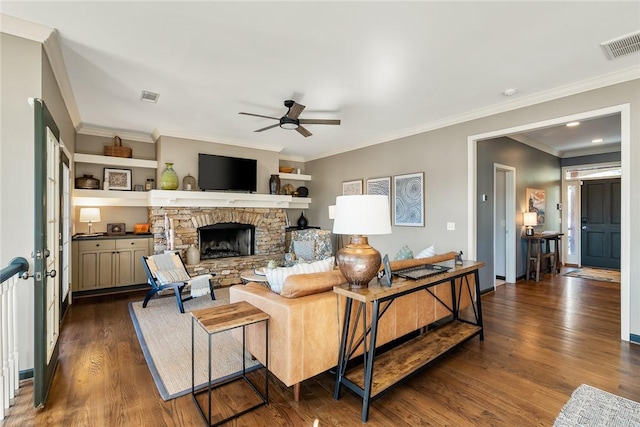 living room with a fireplace, crown molding, dark wood-type flooring, and ceiling fan