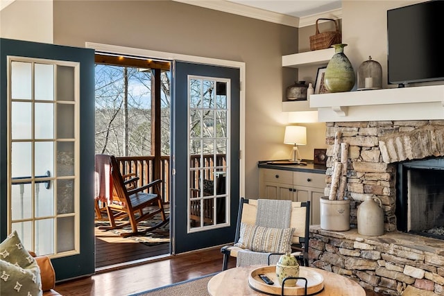 living area featuring a fireplace, ornamental molding, and dark hardwood / wood-style flooring