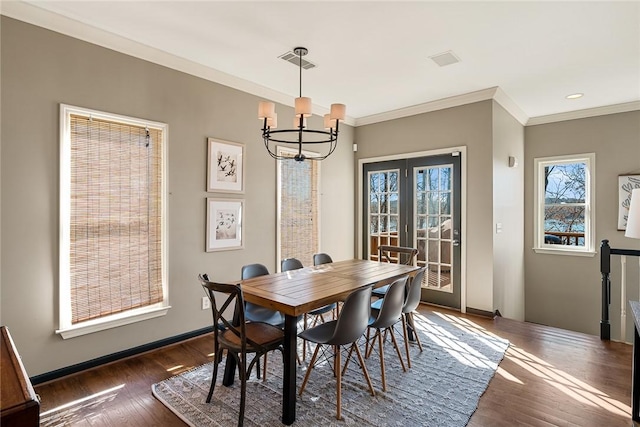 dining room with crown molding, dark wood-type flooring, and an inviting chandelier