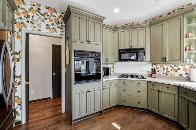 kitchen featuring dark hardwood / wood-style floors, green cabinets, decorative backsplash, and black appliances