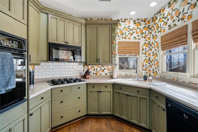 kitchen with tasteful backsplash, wood-type flooring, sink, and black appliances