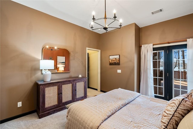 carpeted bedroom with access to exterior and a chandelier