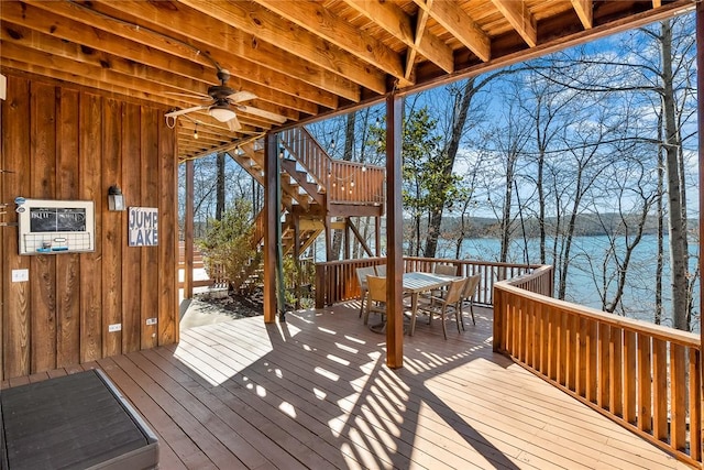 wooden deck with a water view and ceiling fan