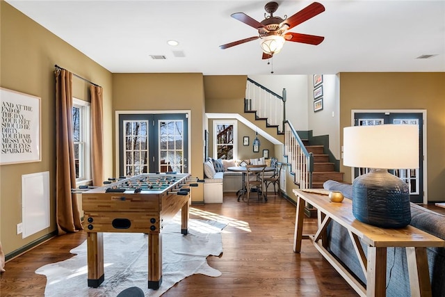 rec room featuring dark hardwood / wood-style floors, ceiling fan, and french doors