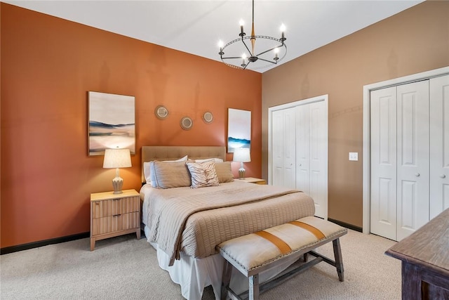 carpeted bedroom with two closets and a chandelier