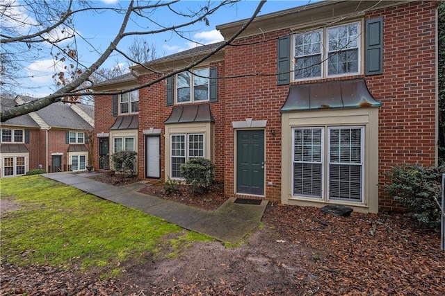 townhome / multi-family property featuring a front lawn