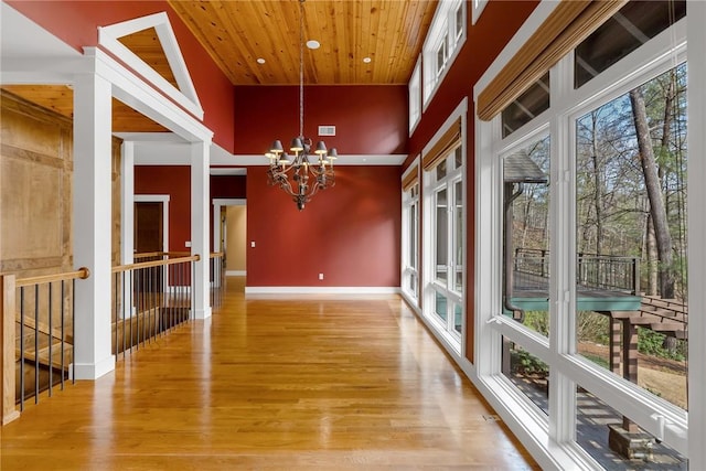 unfurnished sunroom featuring an inviting chandelier and wooden ceiling
