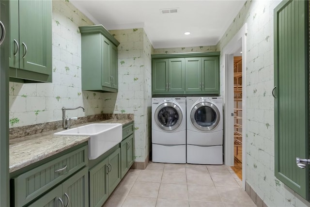 laundry area with independent washer and dryer, cabinets, light tile patterned flooring, and sink