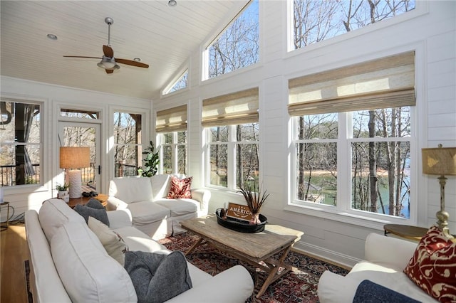 sunroom with a wealth of natural light, wood ceiling, vaulted ceiling, and ceiling fan