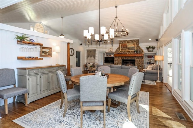 dining room with high vaulted ceiling, a fireplace, visible vents, and dark wood finished floors