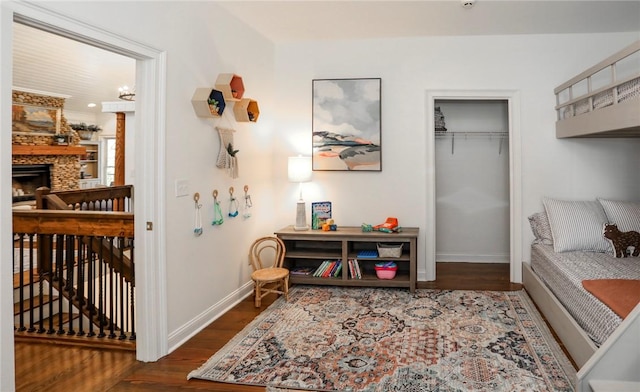 living area featuring dark wood-type flooring, a fireplace, and baseboards