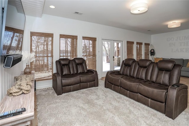 carpeted living room featuring recessed lighting, visible vents, and french doors