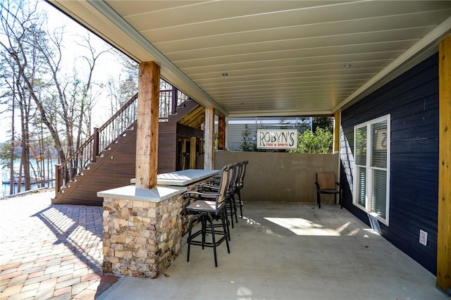 view of patio / terrace with outdoor dry bar and stairway