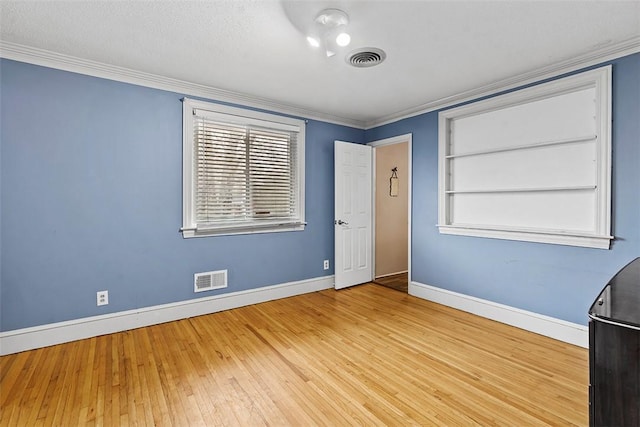 unfurnished room with crown molding and light wood-type flooring