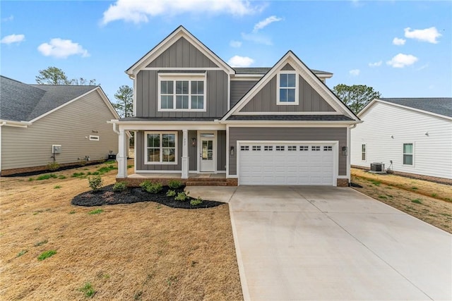 craftsman-style home with central AC, covered porch, board and batten siding, and driveway