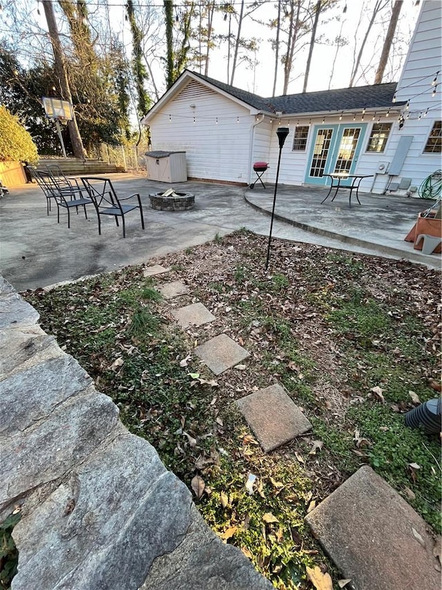 view of yard featuring french doors, an outdoor fire pit, and a patio area