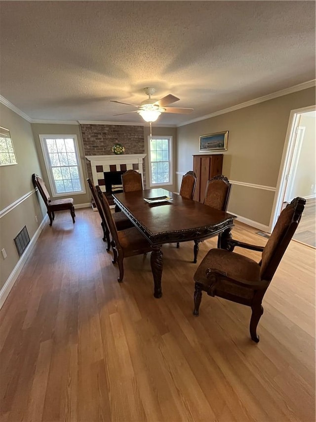 dining space with hardwood / wood-style floors, crown molding, and plenty of natural light