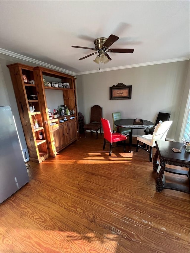 living area featuring crown molding, ceiling fan, and hardwood / wood-style floors