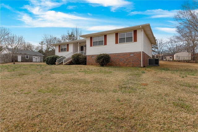 tri-level home featuring central AC unit and a front lawn