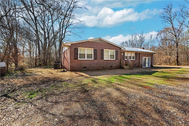 view of front of home with brick siding, crawl space, a front yard, and central air condition unit