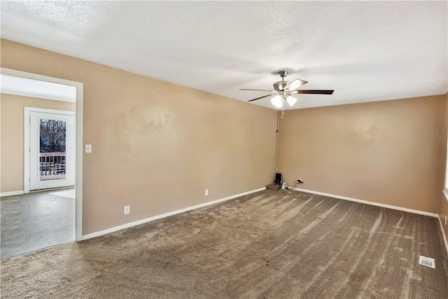 unfurnished room with carpet floors, baseboards, and a textured ceiling