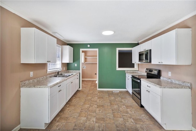 kitchen with a sink, white cabinets, stainless steel appliances, and light countertops