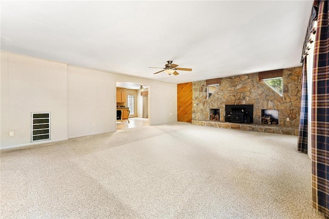 unfurnished living room with ceiling fan, a fireplace, and carpet floors