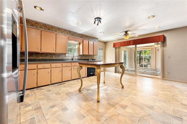 kitchen featuring stainless steel refrigerator, ceiling fan, sink, and backsplash