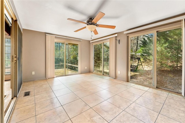 tiled spare room with ceiling fan