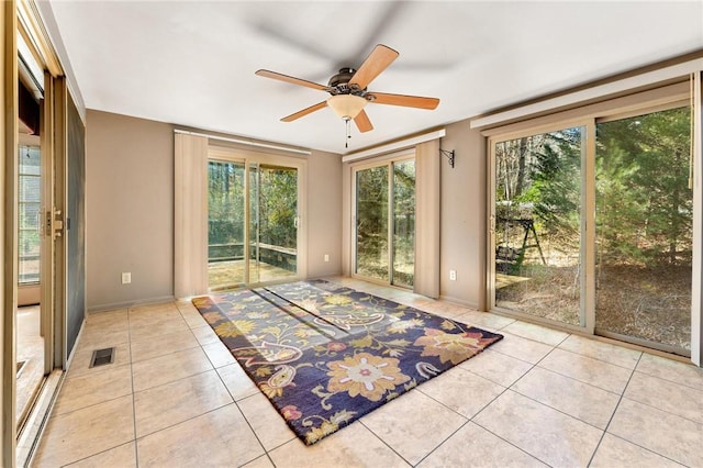 doorway to outside featuring light tile patterned flooring, a healthy amount of sunlight, and ceiling fan