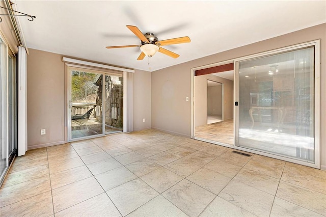 tiled spare room featuring ceiling fan