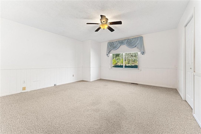 unfurnished room featuring ceiling fan, a textured ceiling, and carpet