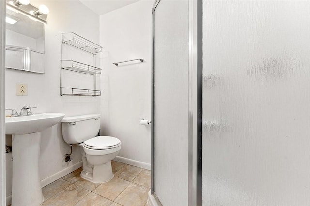 bathroom featuring tile patterned flooring, toilet, and walk in shower