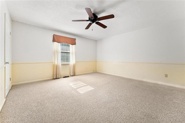 carpeted empty room with ceiling fan and a textured ceiling