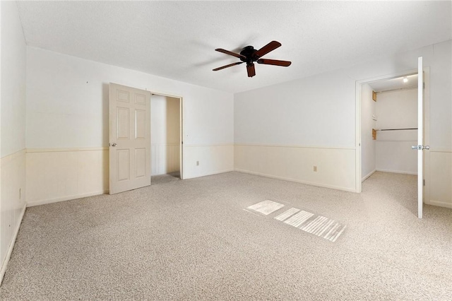 unfurnished bedroom featuring ceiling fan, carpet, and a textured ceiling