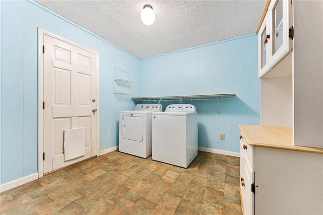 laundry area featuring washing machine and clothes dryer and a textured ceiling