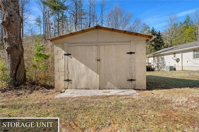 view of outdoor structure with central AC and a lawn