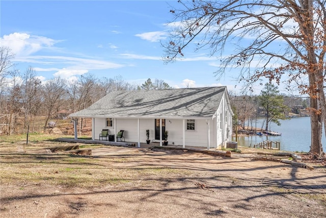 rear view of property with central AC unit and a water view