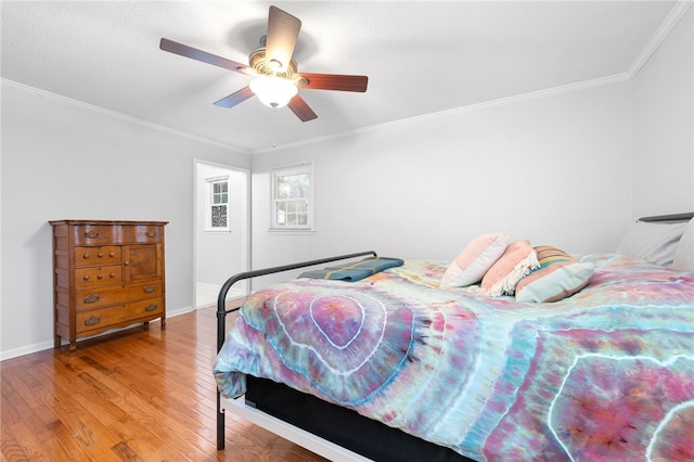 bedroom featuring hardwood / wood-style floors, crown molding, and ceiling fan