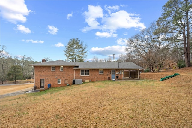 back of property with central AC and a lawn