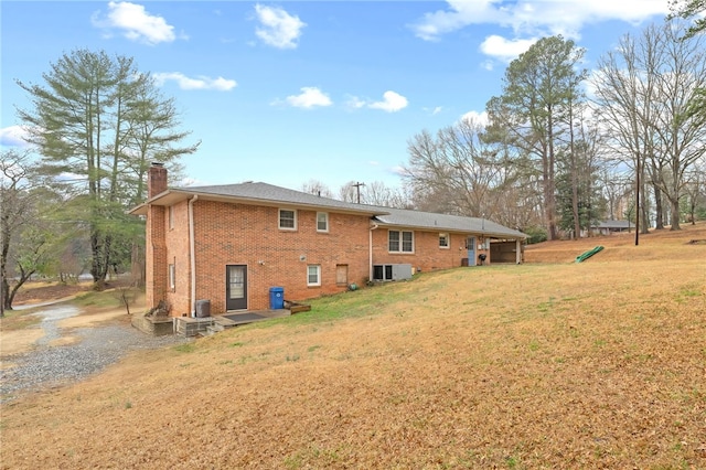 back of house with central AC and a lawn