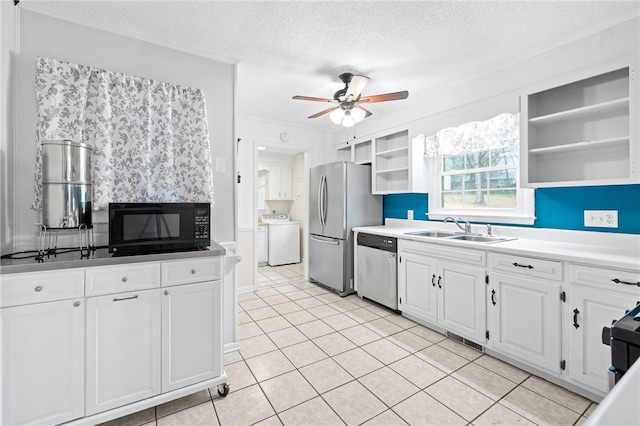 kitchen with sink, ceiling fan, white cabinetry, stainless steel appliances, and washer / clothes dryer