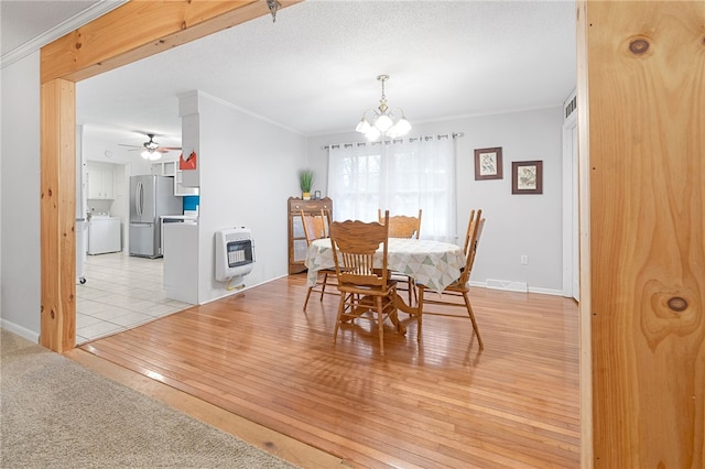 dining area with an inviting chandelier, heating unit, ornamental molding, washer / dryer, and light wood-type flooring