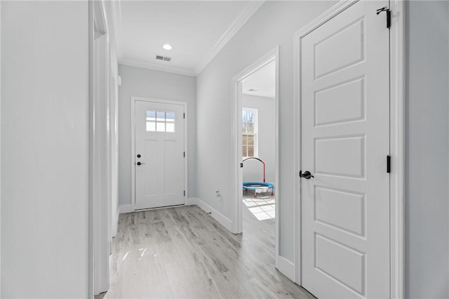 foyer entrance featuring crown molding and light hardwood / wood-style flooring