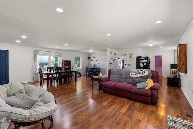 living room featuring dark hardwood / wood-style flooring and crown molding