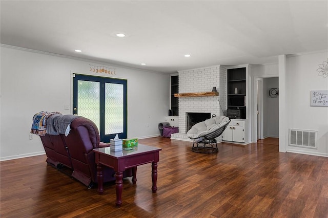 living room featuring a brick fireplace, crown molding, and dark hardwood / wood-style floors