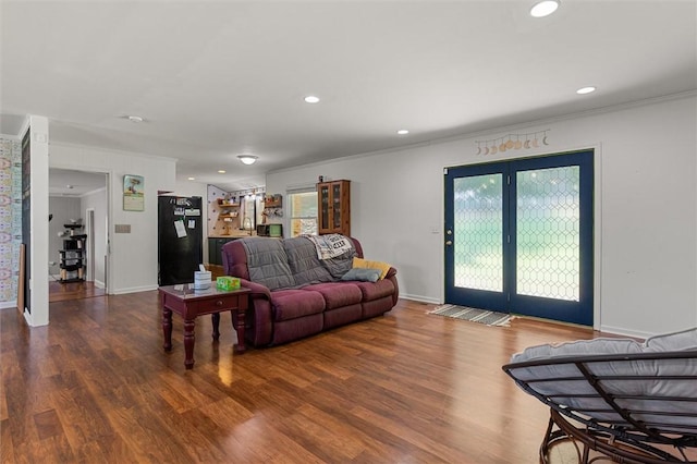 living room with hardwood / wood-style flooring, crown molding, and french doors