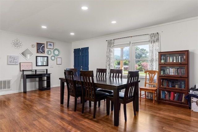 dining area featuring ornamental molding and dark hardwood / wood-style floors