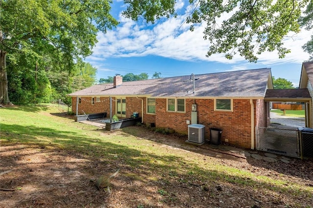 back of house featuring a yard and cooling unit